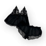 Flatlay black lace lingerie set on a white background