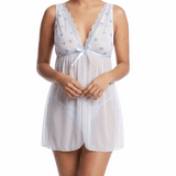 Woman wearing a light blue sleeveless dress with a pattern on a white background