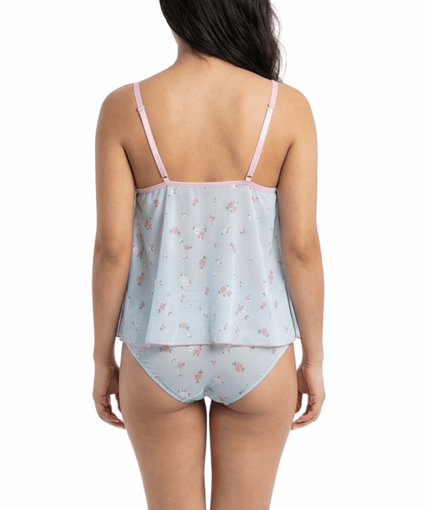 Woman wearing a light blue satin nightgown with pink floral pattern on a white background