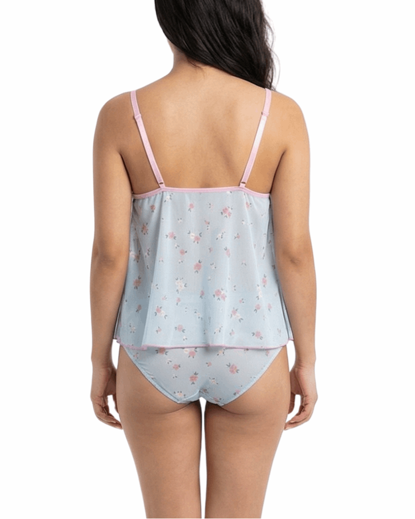 Woman wearing a light blue satin nightgown with pink floral pattern on a white background