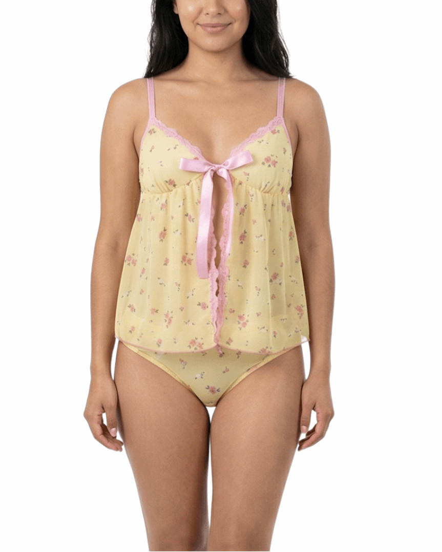 Woman wearing a yellow floral nightgown with pink trim on a white background
