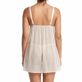 Woman wearing a sheer white nightgown with thin straps on a white background