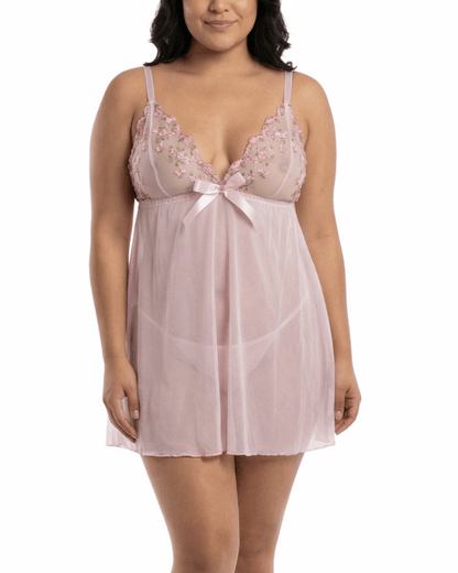 Woman wearing a light pink lace nightgown on a white background