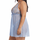 Woman wearing a light blue lace nightgown on a white background