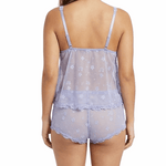 Woman wearing a sheer floral top and shorts set on a white background