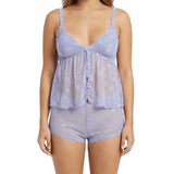 Woman wearing a light purple lace top and shorts on a white background