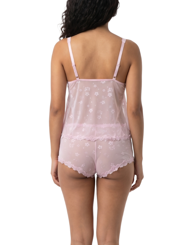 Woman wearing a pink lace cami set on a white background