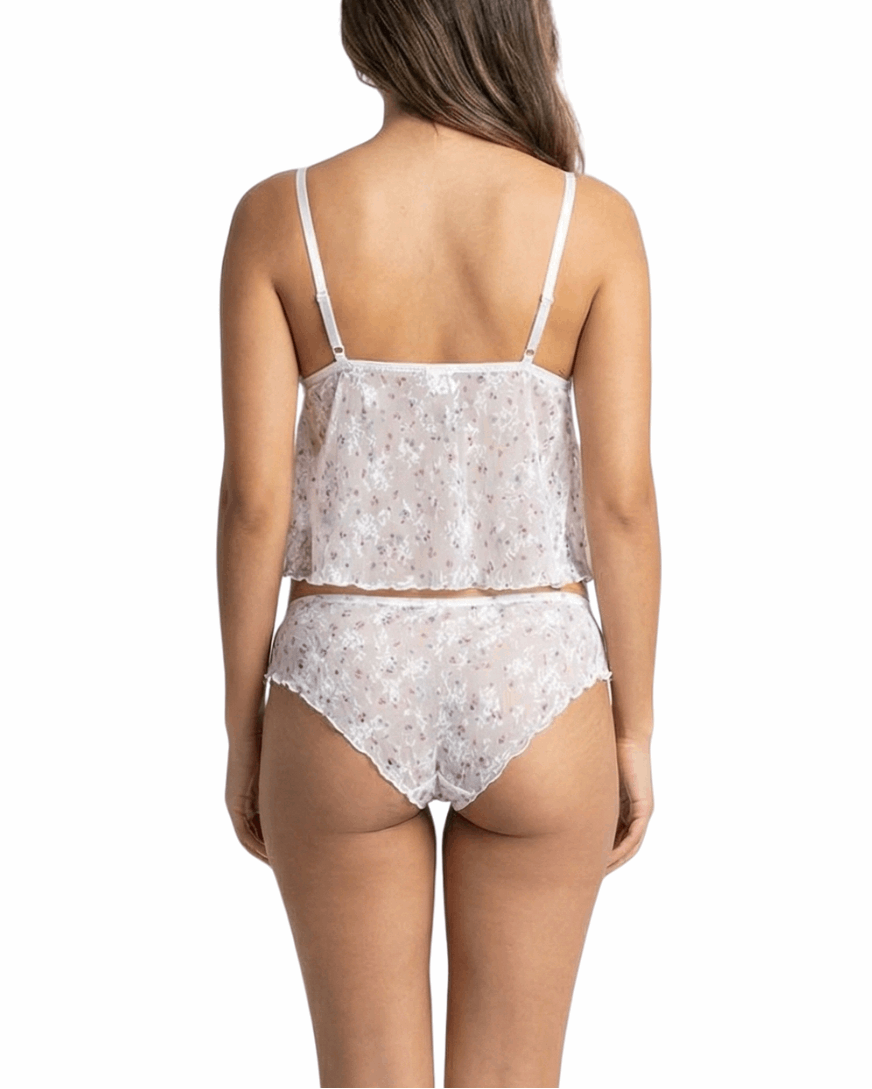 Woman wearing a white floral lingerie set on a white background