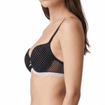 Woman wearing a black polka dot bra on a white background
