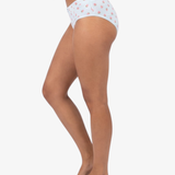 Side view of a model wearing blue high-waisted briefs with a small pink strawberry pattern, shown against a plain light gray background.