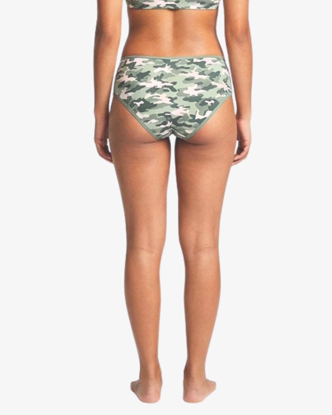 Rear view of a model wearing camouflage hipster bottoms against a light gray studio background.