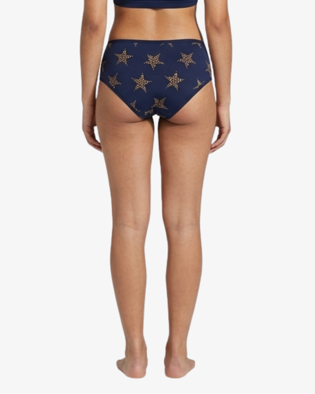 Rear view of a model wearing high-waisted navy blue bikini bottoms with a gold star pattern, shown against a plain white background.