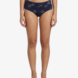 A model is shown from the waist down wearing navy blue bikini bottoms with a gold star pattern, set against a plain white background.
