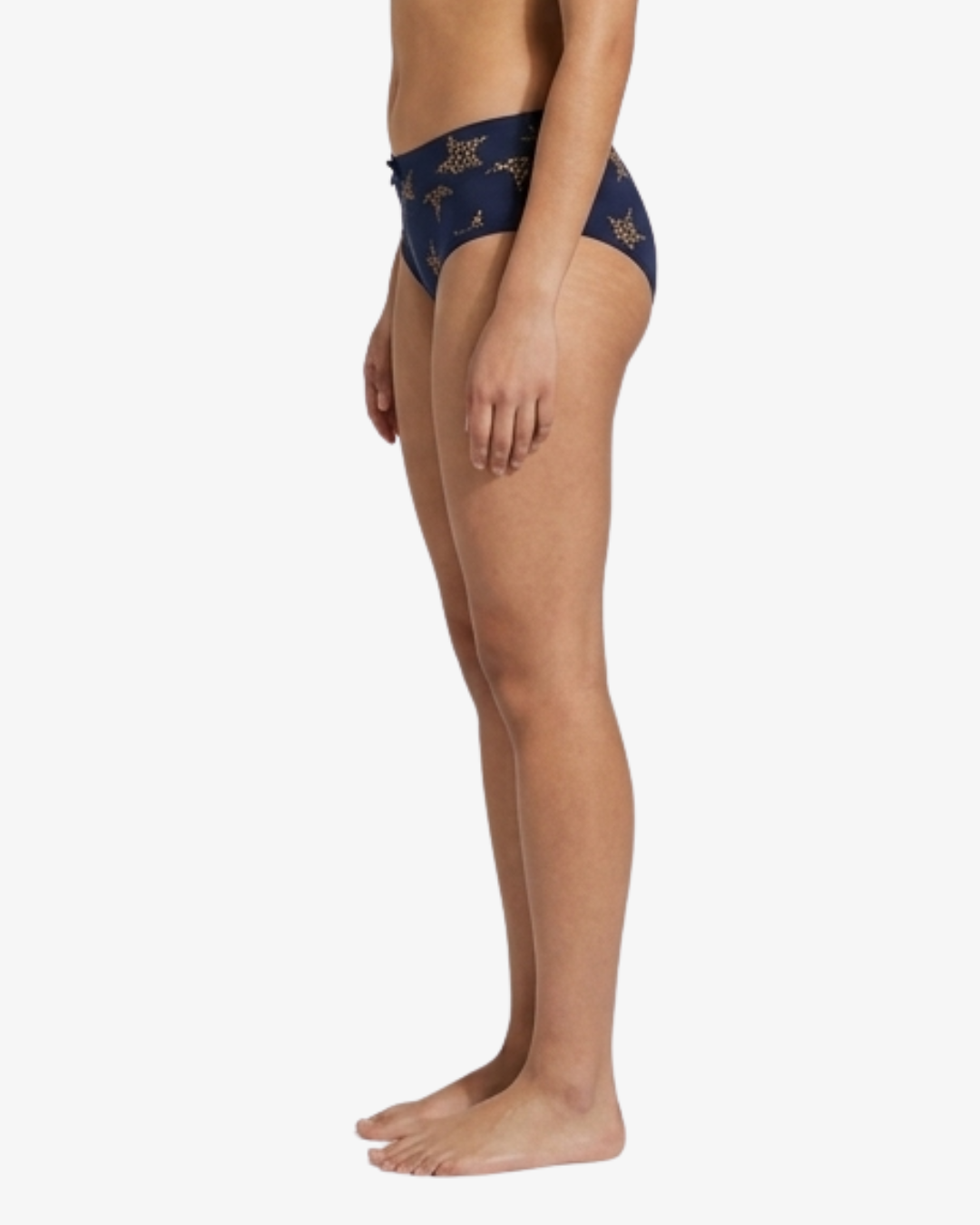 Side view of a model wearing navy blue bikini bottoms with a gold star pattern, shown against a plain white background.