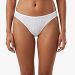 White bikini bottom with small black polka dots, shown on a model against a light gray background.