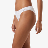 White bikini bottom with small black polka dots, shown on a model against a light gray background.