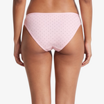 Pink bikini bottom with small brown polka dots, shown on a model against a light gray background.