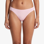 Pink bikini bottom with small brown polka dots, shown on a model against a light gray background.