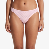 Pink bikini bottom with small brown polka dots, shown on a model against a light gray background.