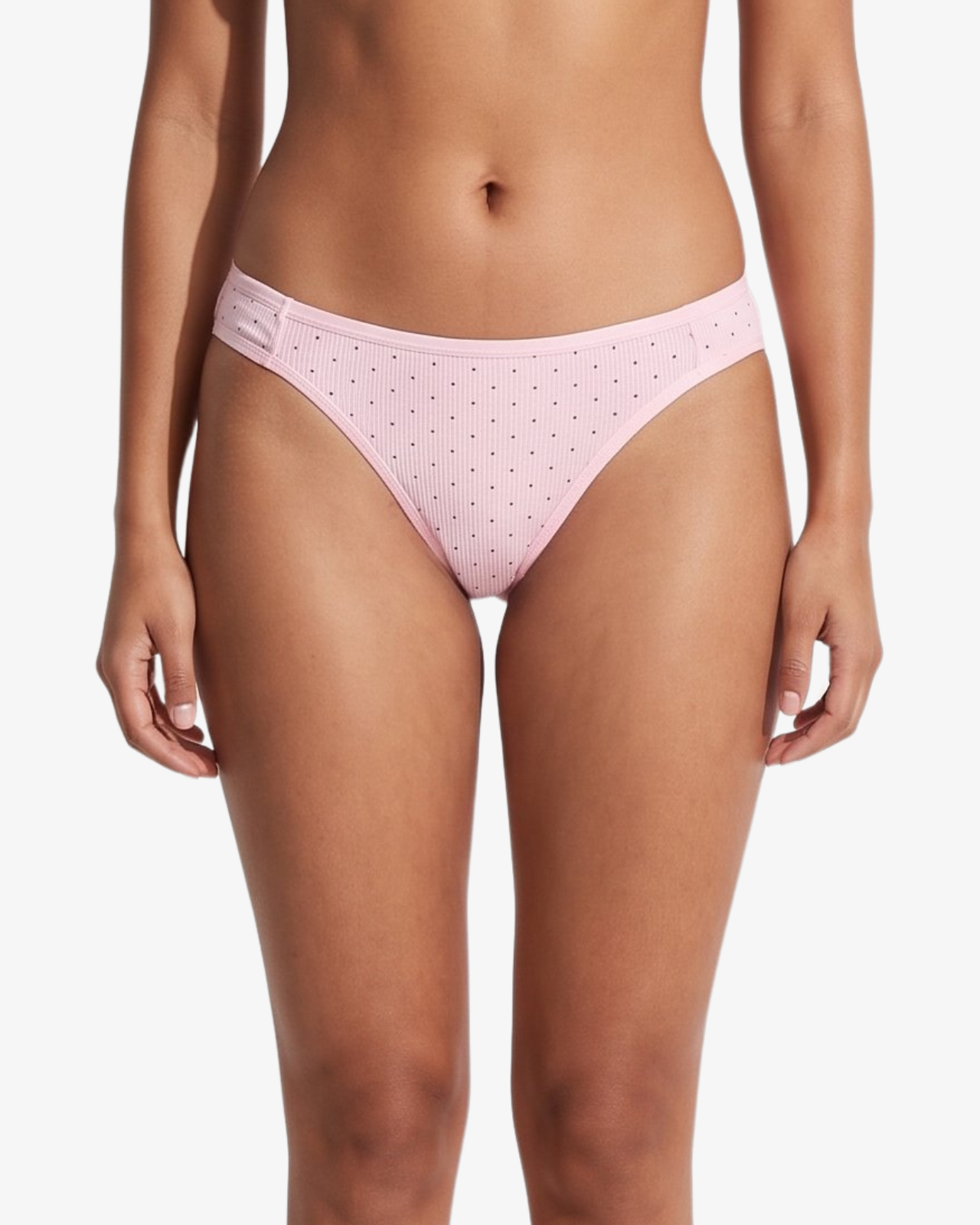 Pink bikini bottom with small brown polka dots, shown on a model against a light gray background.