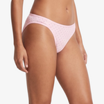 Pink bikini bottom with small brown polka dots, shown on a model against a light gray background.