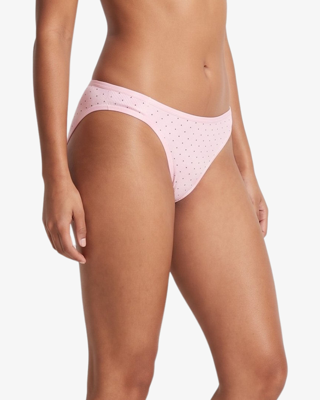 Pink bikini bottom with small brown polka dots, shown on a model against a light gray background.