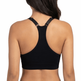 Woman in a black sports bra against a white backround.