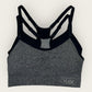 Gray sports bra with black straps on a white background