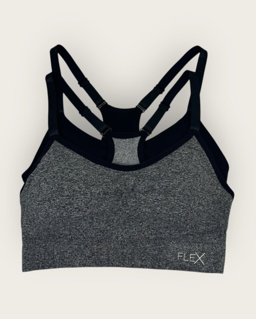 Gray sports bra with black straps on a white background
