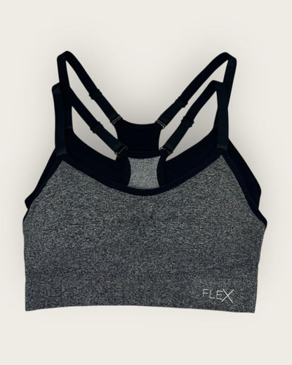 Gray sports bra with black straps on a white background