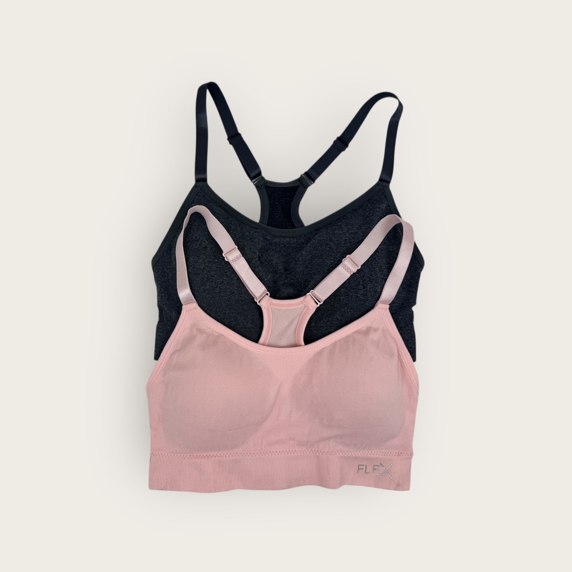 Pink and black bra on a light gray background