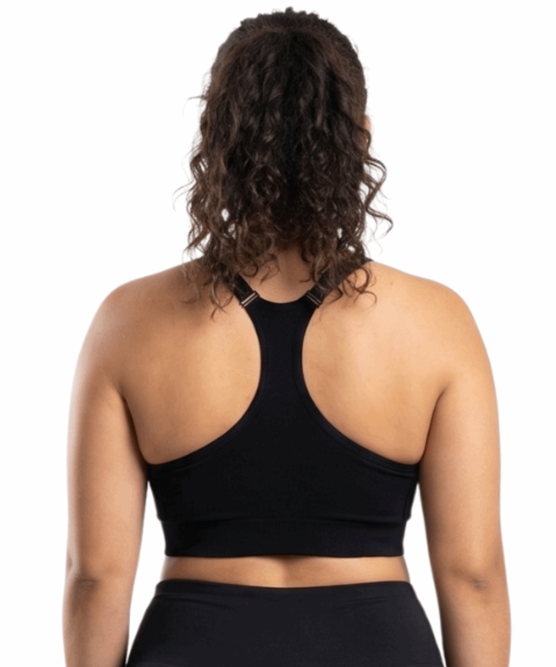 Woman in a black sports bra against a white background.