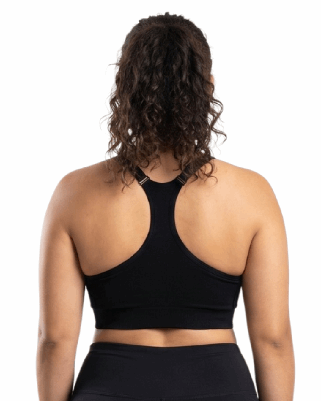 Woman in a black sports bra against a white background.