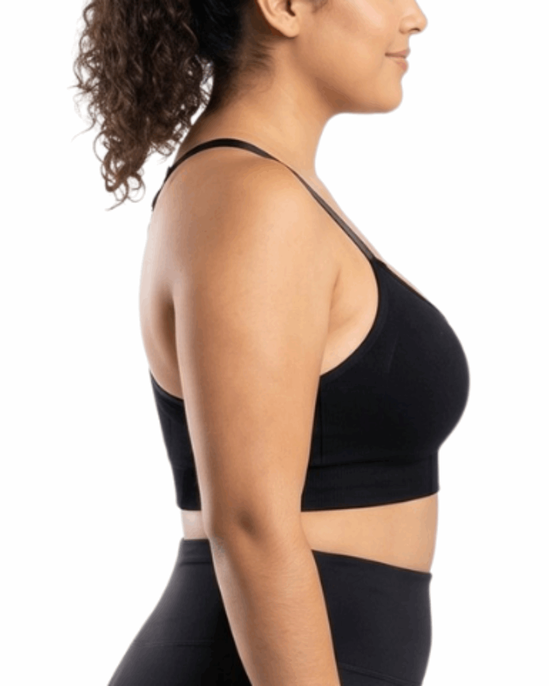 Woman in a black sports bra against a white background.