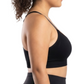 Woman in a black sports bra against a white background.