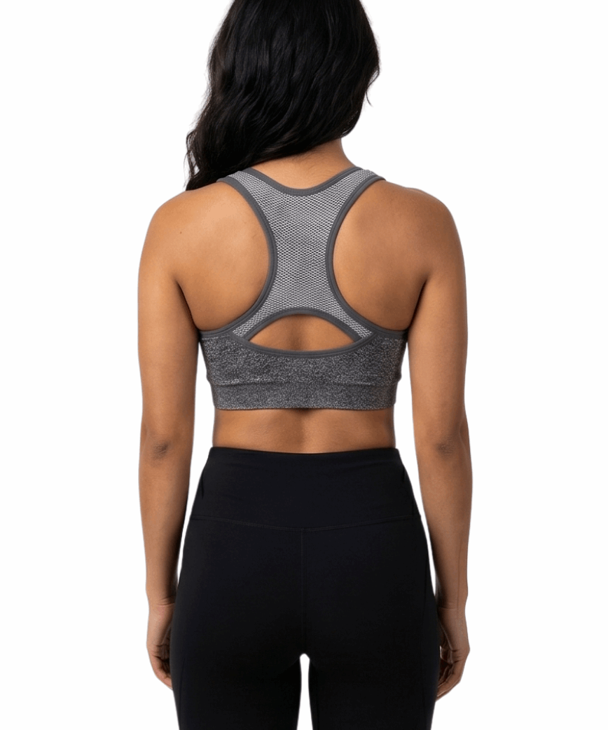 Woman wearing a gray sports bra and black leggings on a white background