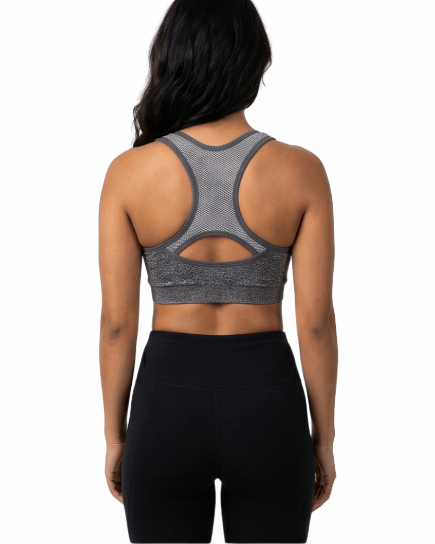 Woman wearing a gray sports bra and black leggings on a white background