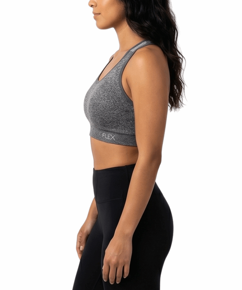 Woman wearing a gray sports bra and black leggings on a white background