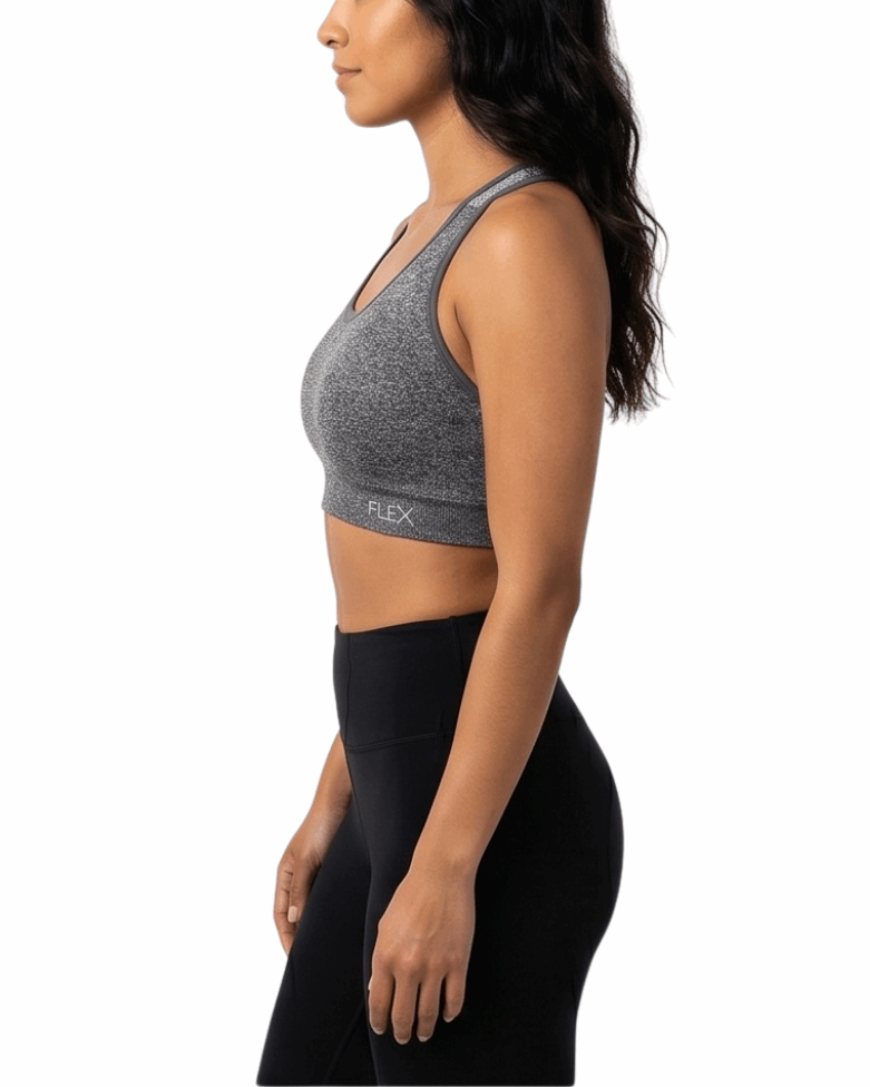 Woman wearing a gray sports bra and black leggings on a white background
