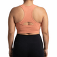 Person wearing a peach sports bra and black leggings on a white background