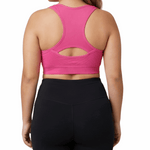Woman wearing a pink sports bra and black leggings on a white background