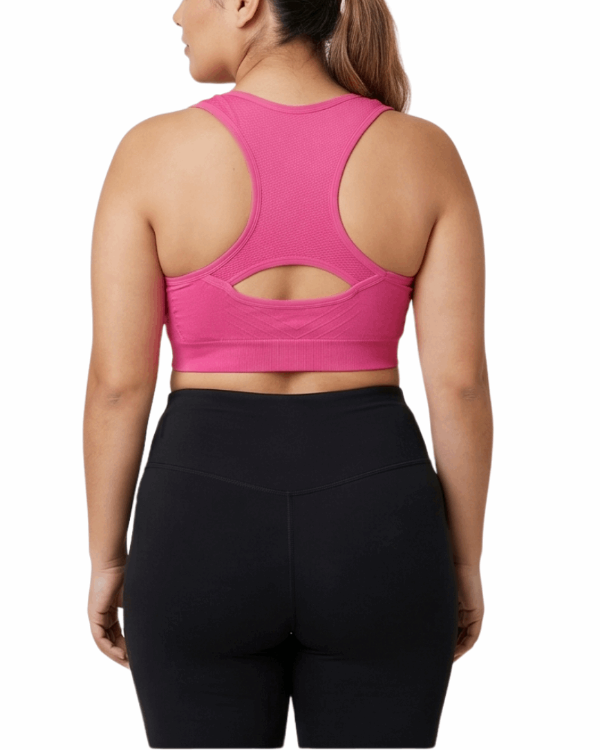 Woman wearing a pink sports bra and black leggings on a white background