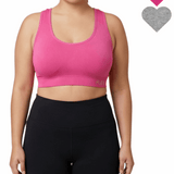 Person wearing a pink sports bra and black leggings on a white background