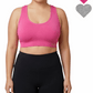 Person wearing a pink sports bra and black leggings on a white background