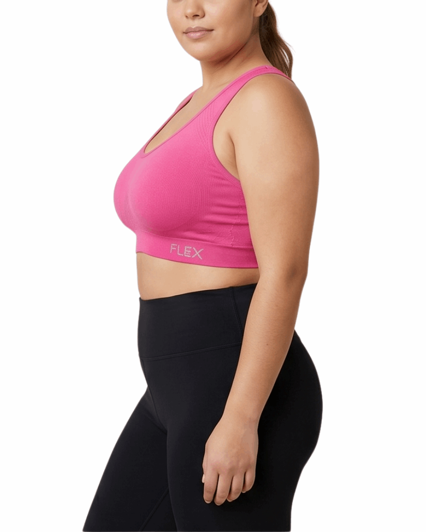 Woman wearing a pink sports bra and black leggings on a white background