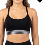 Woman wearing a black sports bra with striped design on a white background