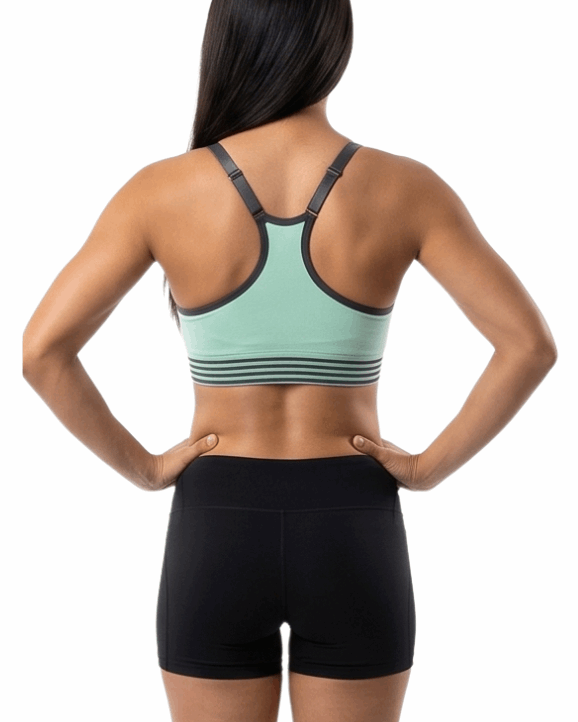 Woman wearing a green sports bra and black shorts on a white background