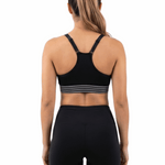 Person wearing a black sports bra and leggings on a white background