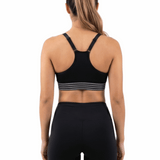 Person wearing a black sports bra and leggings on a white background