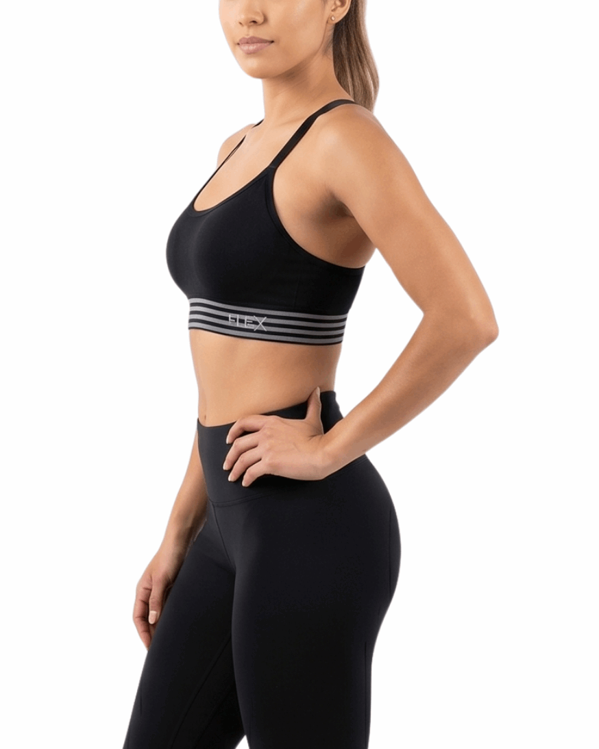 Woman wearing a black sports bra and leggings on a white background